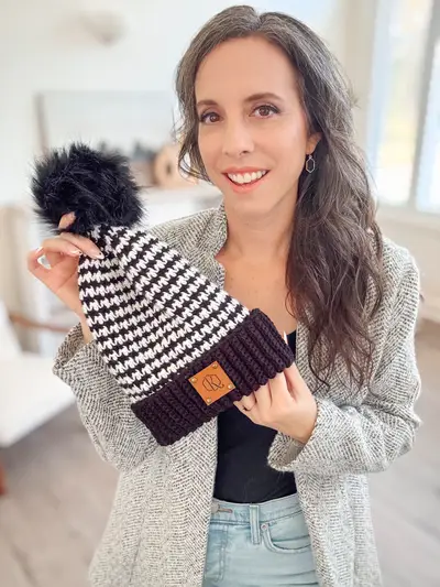 Woman holding a navy and white Houndstooth Crochet Beanie