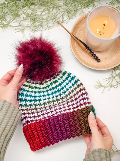 Burgundy Houndstooth Crochet Beanie with a matching pom pom and a candle