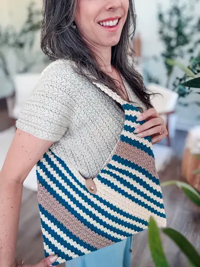 Woman carrying the striped Just a Rectangle Crochet Bag on her shoulder