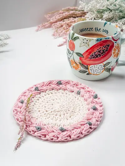 Pink and cream Macchiato Crochet Coaster under a floral mug