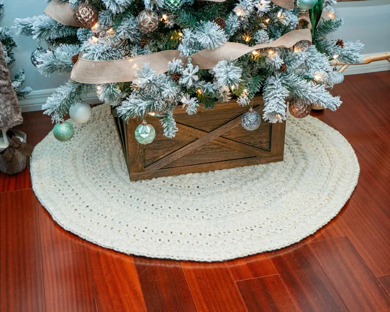 Cream Macchiato Crochet Tree Skirt under a flocked Christmas tree in a wood crate