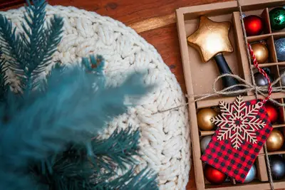 Macchiato Crochet Tree Skirt texture beside a box of red and gold ornaments