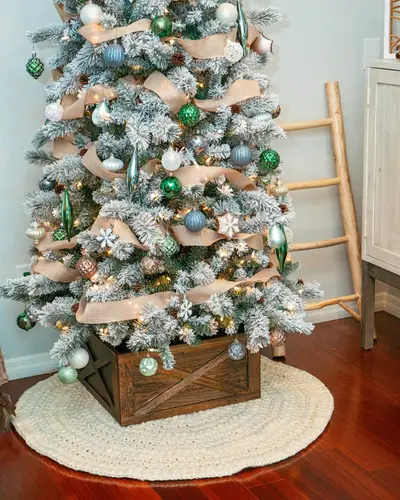 Flocked Christmas tree in a wooden crate on the cream Macchiato Crochet Tree Skirt