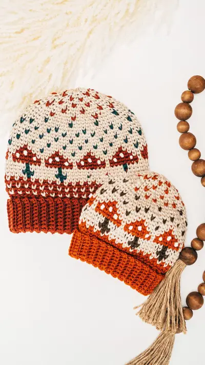 Two Mushroom Crochet Beanies with rust brims and a wooden bead garland