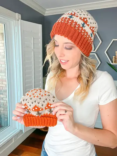 Woman wearing a rust Mushroom Crochet Beanie and holding another