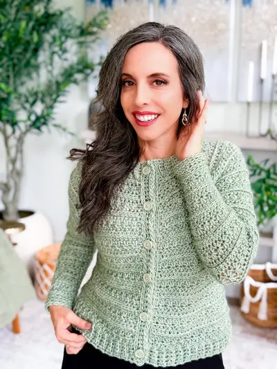 Woman wearing the sage green Petal Loop Cardigan, a fitted button front cardigan