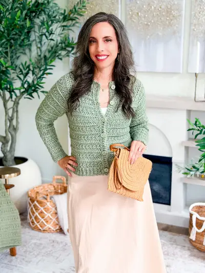 Full view of the sage Petal Loop Cardigan with a long cream skirt