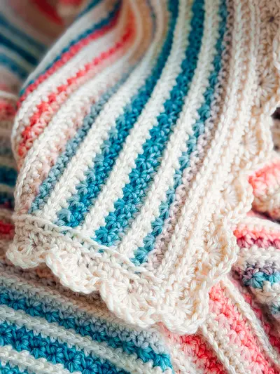 Close up of teal and pink stripes on the Petal Loop Stitch Striped Blanket
