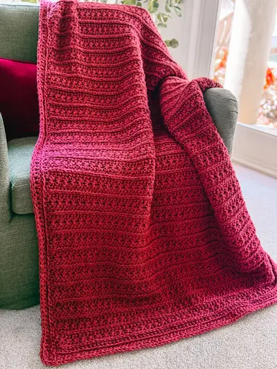 Red Petal Loop Stitch Textured Blanket draped over a sofa arm