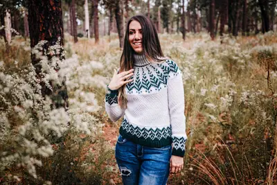 Woman in the Pine Fair Isle Crochet Sweater in a field