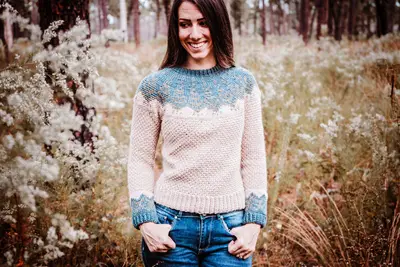 Pine Fair Isle Crochet Sweater in cream with a blue yoke worn outdoors