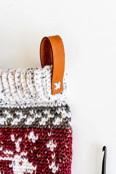 Close up of the leather hanging loop and colorwork cuff on the Prancing Deer Holiday Stocking