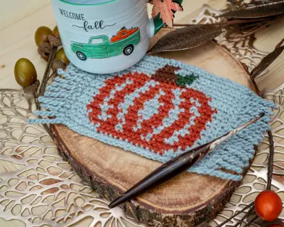 Pumpkin Coffee Mug Rug in light gray and rust under a Welcome Fall mug