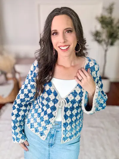 Smiling woman in the blue and cream granny stitch Rainbow Hues Crochet Cardigan