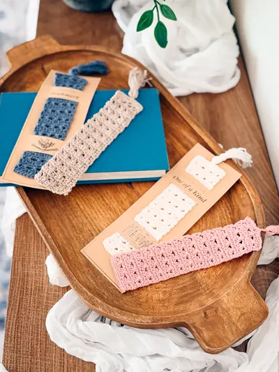 Reed Crochet Bookmarks on card backings next to a teal book