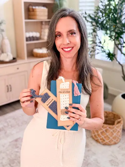 Smiling woman holding a Reed Crochet Bookmark on its gift card