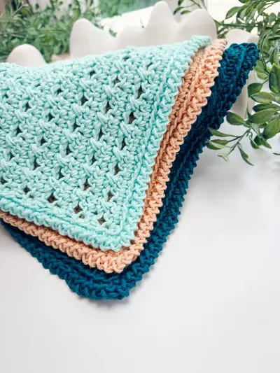 Stack of Reed Washcloths in aqua, peach and teal