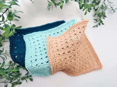 Three Reed Washcloths fanned out in navy, aqua and peach