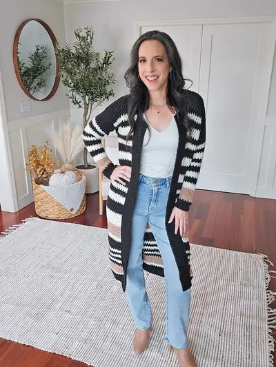 Smiling woman in the black and white striped Shortbread Crochet Duster with jeans
