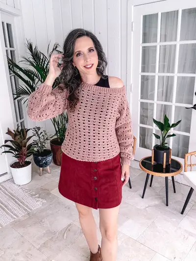 Pink Sparrow Sweater worn off the shoulder with a red skirt