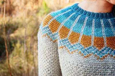 Close up of the blue and gold Traveler Fair Isle yoke on a gray sweater