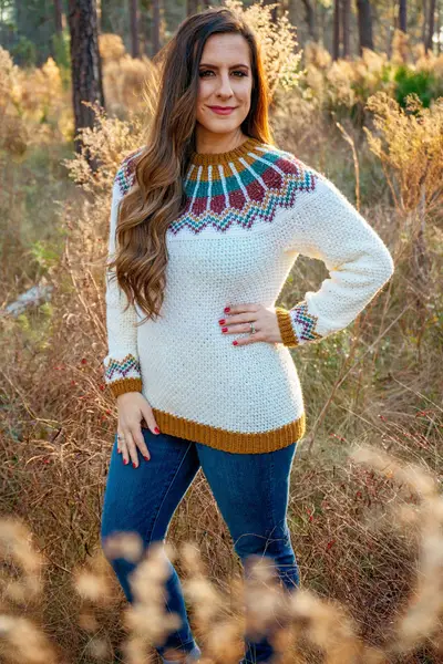 Woman wearing the white Traveler Fair Isle Crochet Sweater with a gold, teal and red yoke