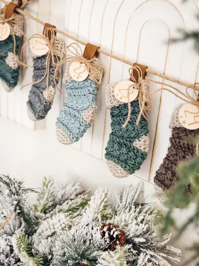 Mini Wheat Stitch Advent Crochet Stockings in blue, gray and teal with round wooden tags