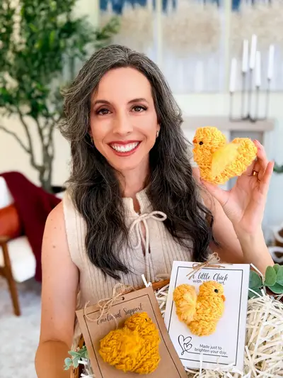 Smiling woman holding a basket of yellow Wheat Stitch Chicks