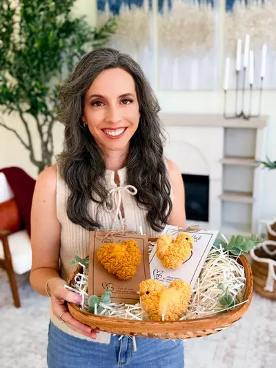 Woman holding a basket of yellow Wheat Stitch Chicks with gift tags