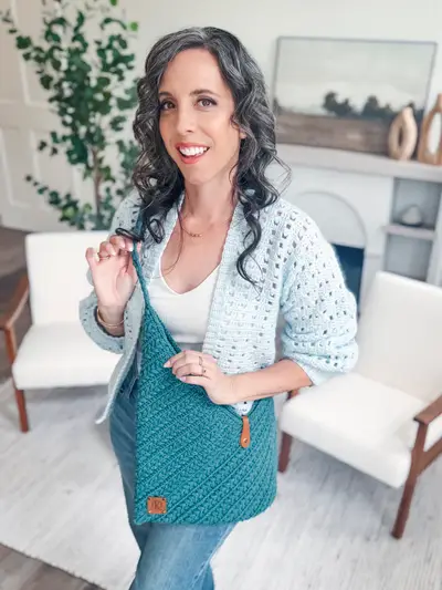 Woman wearing the teal Wheat Stitch Crochet Bag