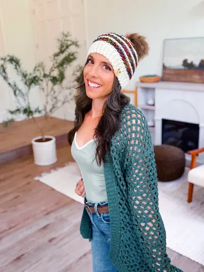 Woman wearing a striped Wheat Stitch Crochet Beanie and a green cardigan