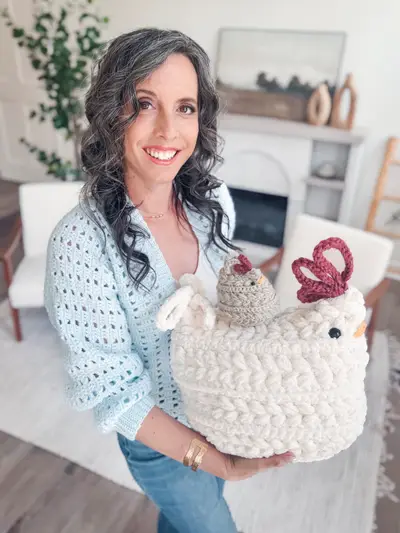 Woman holding a white Wheat Stitch Crochet Chicken with a baby chick on top