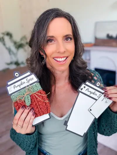 Smiling woman holding rust Wheat Stitch Pumpkin Cozies on gift cards