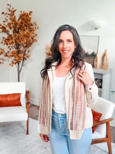 Woman wearing the blush and cream Wheat Stitch Crochet Scarf with fringe