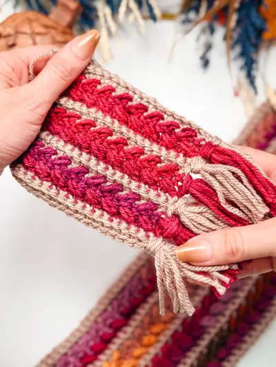 Close up of the wheat stitch texture and fringe on a red Wheat Stitch Crochet Scarf