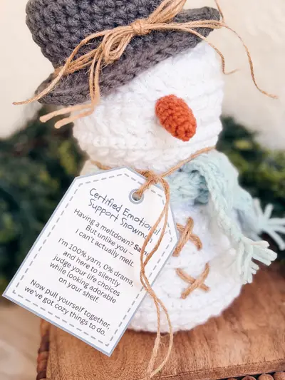 Gray hatted Wheat Stitch Crochet Snowman with a carrot nose and a printed tag