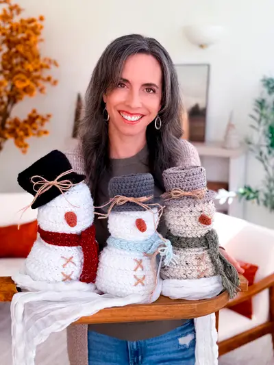Woman holding a family of three Wheat Stitch Crochet Snowmen
