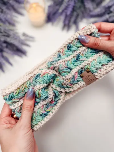 Close up of a speckled teal and cream Wheat Stitch Ear Warmer