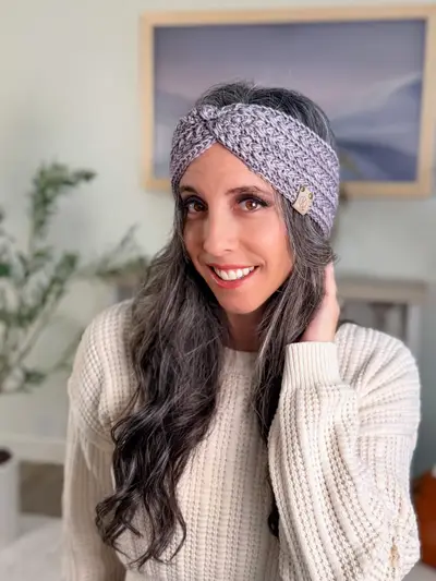 Smiling woman wearing a lavender Wheat Stitch Ear Warmer