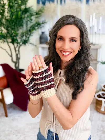 Smiling woman wearing striped Wheat Stitch Fingerless Mittens