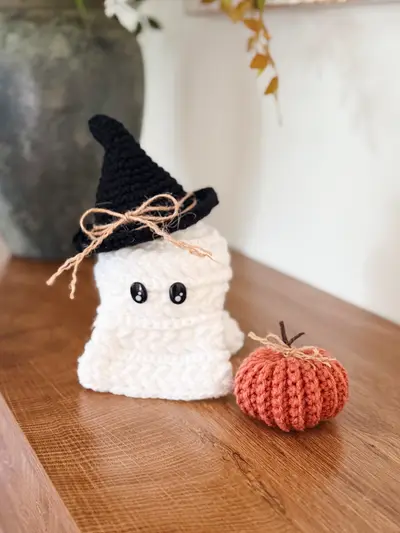 White Wheat Stitch Ghost with a black witch hat next to a rust crochet pumpkin