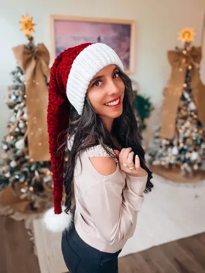 Woman wearing the red Wheat Stitch Santa Hat with a white brim