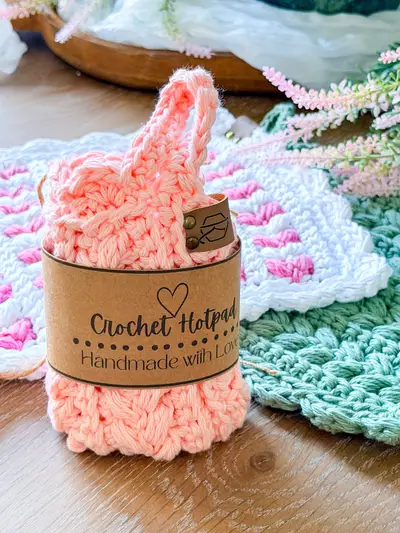 Peach Wheat Stitch Scalloped Hotpad rolled with a Crochet Hotpad label