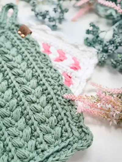 Close up of a sage Wheat Stitch Scalloped Hotpad with a hanging loop
