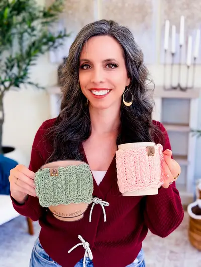 Woman holding mugs with sage and pink Wheat Stitch Scalloped Mug Cozies