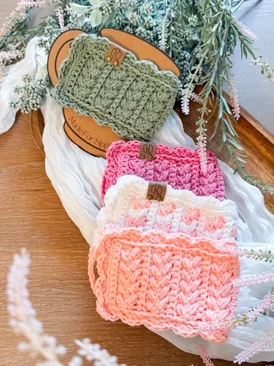 Wheat Stitch Scalloped Mug Cozies in sage, pink and peach stacked on a mug card