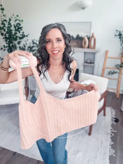 Woman holding up the peach Wheat Stitch Tank Top