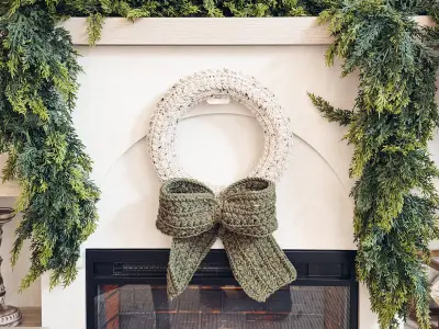 Cream Wheat Stitch Wreath with a sage bow over a mantel
