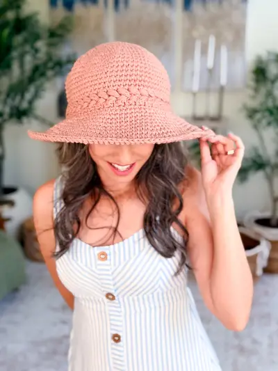 Woman wearing a pink Wheatfield Sun Hat with a wide floppy brim