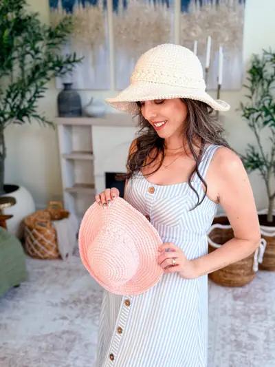 Woman wearing a cream Wheatfield Sun Hat holding a pink one